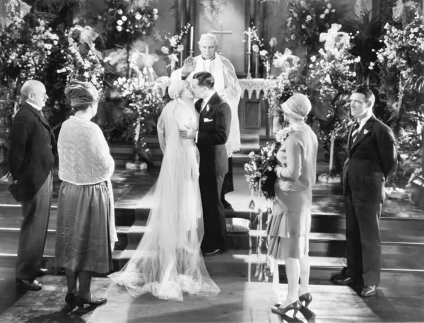 Nevěsta a ženich líbat po svatebním obřadu — Stock fotografie