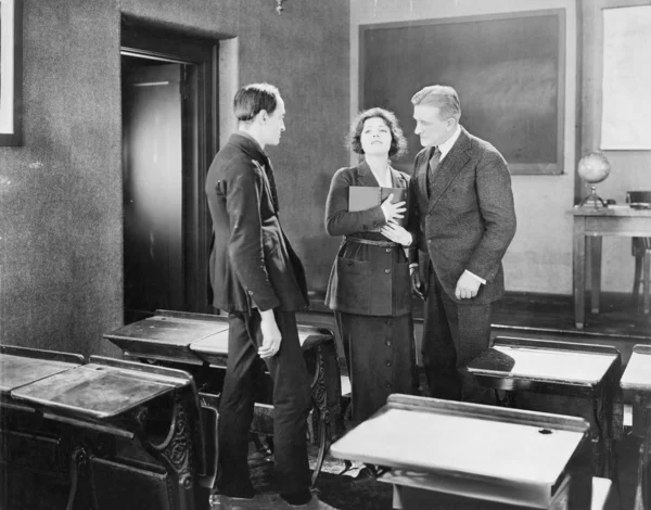 Jonge vrouw uitvoeren voor twee mannen in een class kamer — Stockfoto