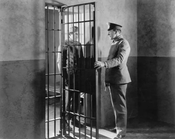 Poliziotto e prigioniero in una cella — Foto Stock
