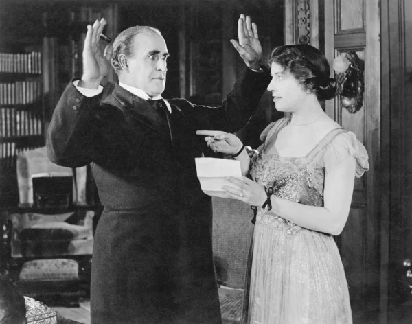 Mulher com uma carta na mão apontando para um homem — Fotografia de Stock
