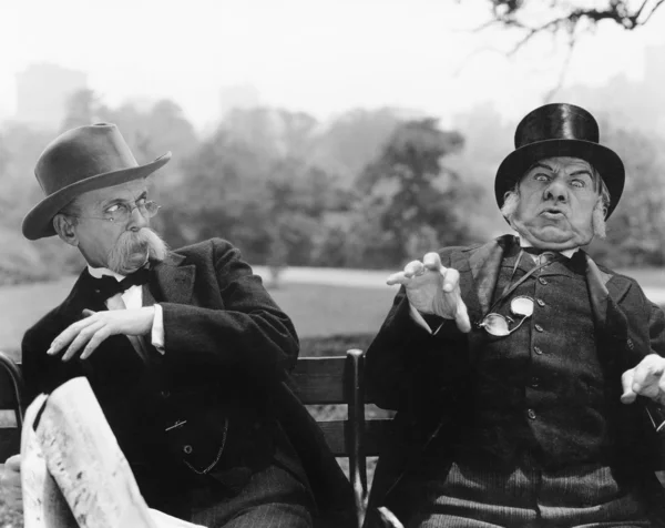 Δύο άνδρες συνεδρίαση σε έναν πάγκο που αναζητούν σοκαρισμένος — Φωτογραφία Αρχείου