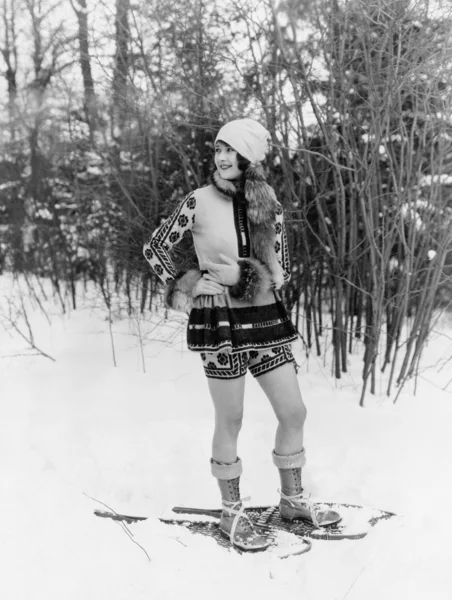 Ormanın içinden kar ayakkabıları ile yürüyen genç bir kadın — Stok fotoğraf