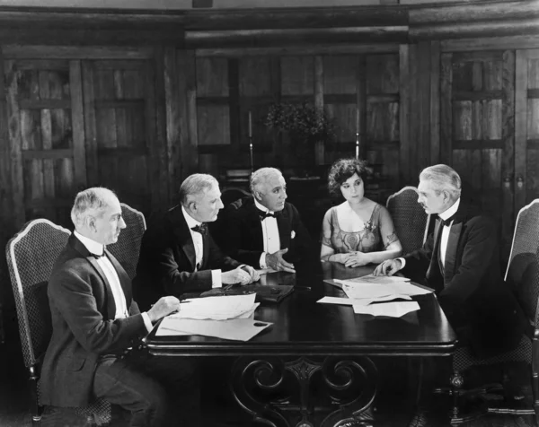 Gruppo di uomini seduti con una giovane donna in una sala riunioni — Foto Stock