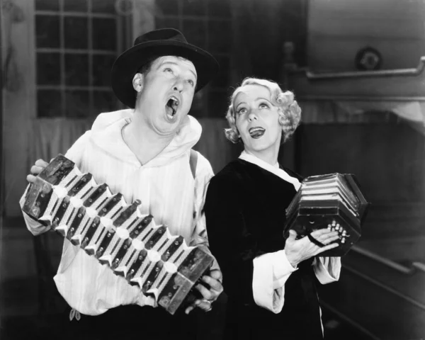 Couple singing while playing two accordions — Stok fotoğraf