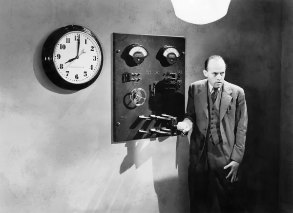 Man standing next to an electrical switch — Stok fotoğraf