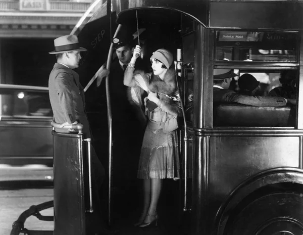 年轻女子骑着一辆公共汽车与一年轻男子调情 — 图库照片