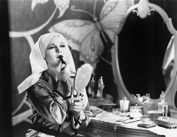 Mujer en tocador aplicando cosméticos Imagen de stock