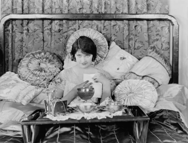 Frau frühstückt im Bett Stockbild