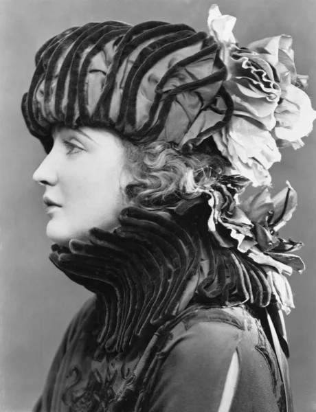 Vrouw dragen uitgebreide hoed Stockfoto