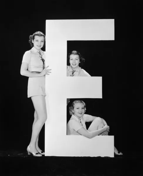 Mujeres posando con enorme letra E — Foto de Stock
