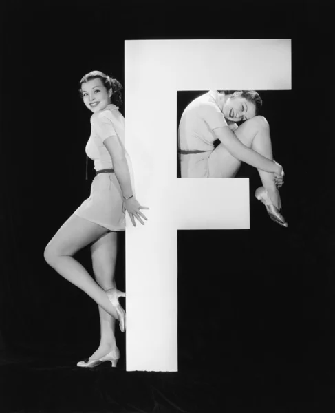 巨大な手紙 f を持つ女性 ストック画像