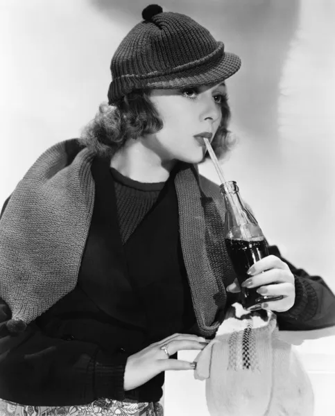 Porträtt av kvinna dricka ur flaska läsk Stockfoto