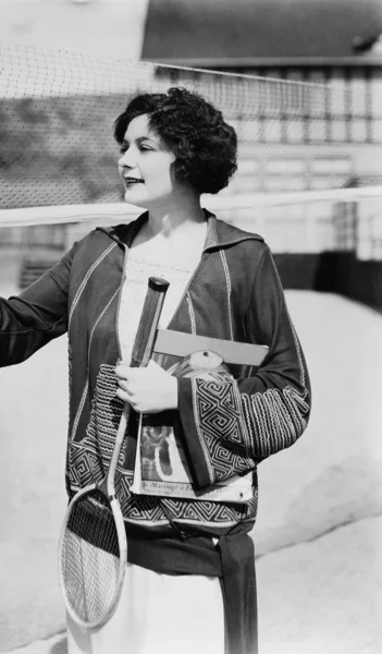 Portrait of woman with badminton racket and magazine — Stock Photo, Image