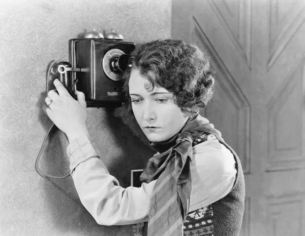Young woman holding onto a telephone Stock Picture