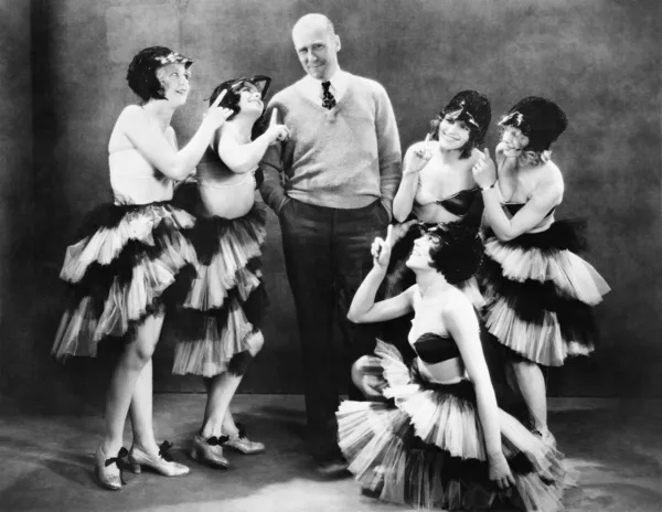 Cinco mujeres jóvenes bailando alrededor de un hombre — Foto de Stock