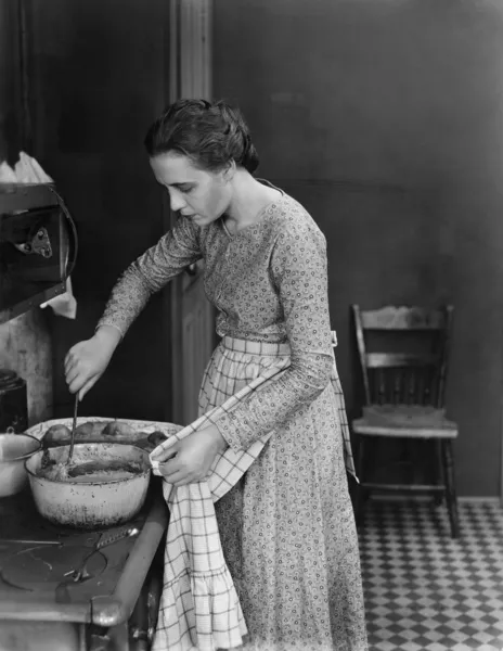 Профиль молодой женщины, готовящей еду на кухне Лицензионные Стоковые Фото