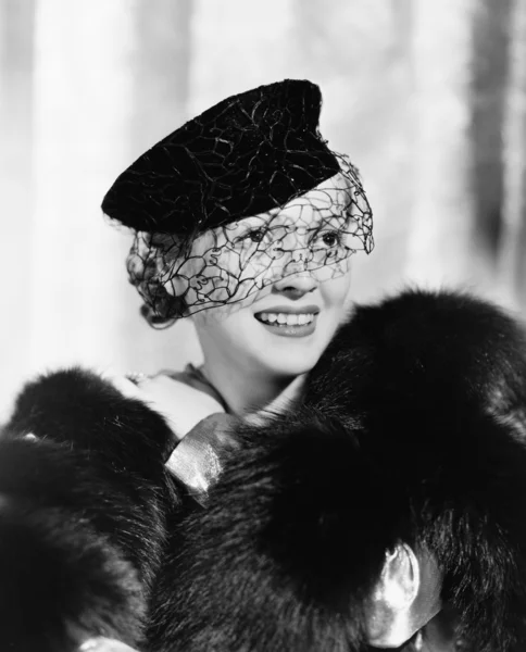 Portrait d'une jeune femme en chapeau avec un voile et une étole de fourrure souriante Images De Stock Libres De Droits