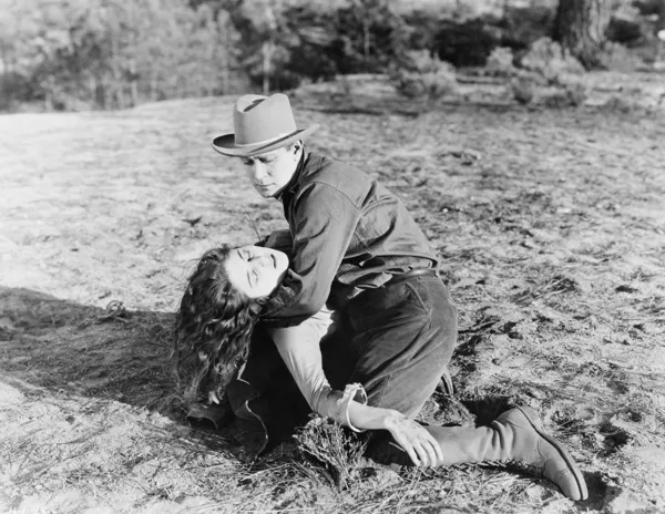 Jeune homme tenant une jeune femme inconsciente — Photo