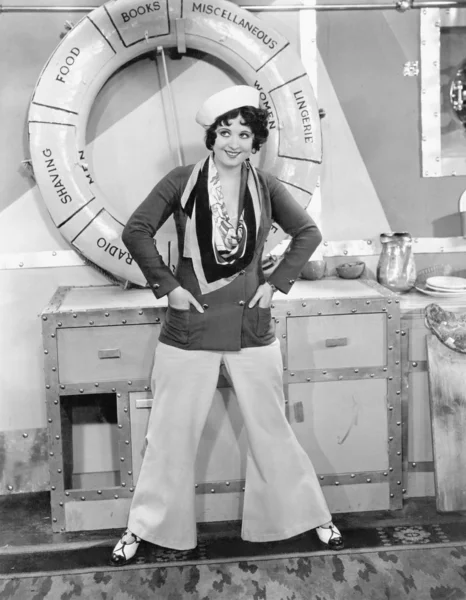 Woman in a sailors outfit in front of a life preserver Stock Photo