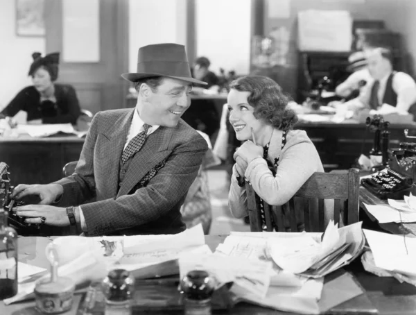 Мужчина и женщина вместе в офисе флиртуют друг с другом Стоковое Изображение