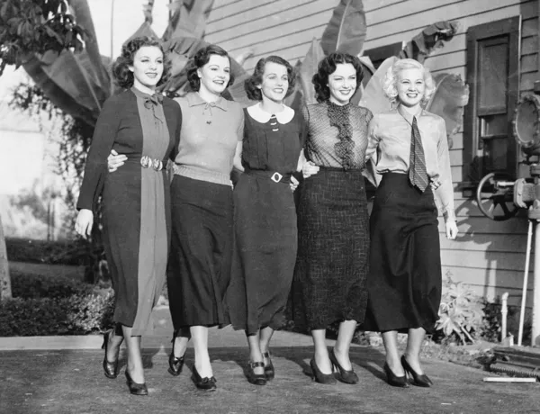 Vijf vrouwen poseren in een achtertuin Stockafbeelding