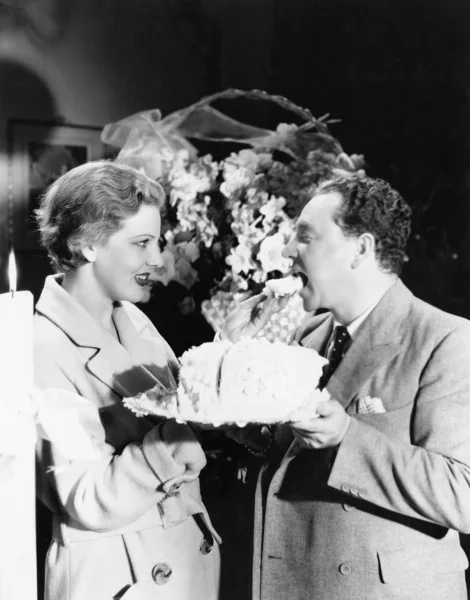 Woman feeding a man a piece of cake Stock Picture