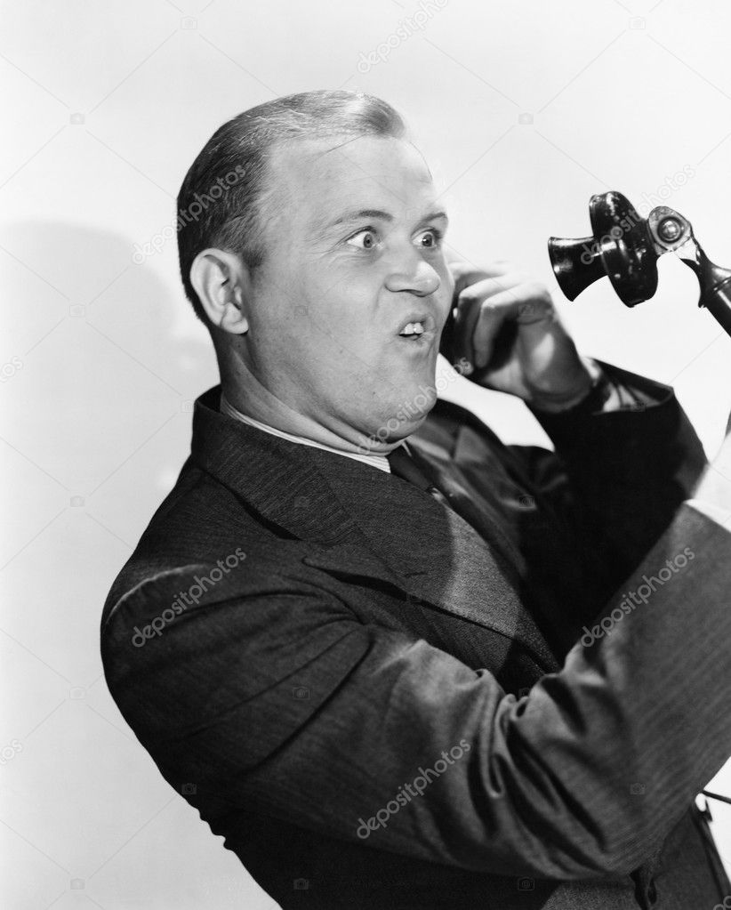 Man with funny expression using telephone
