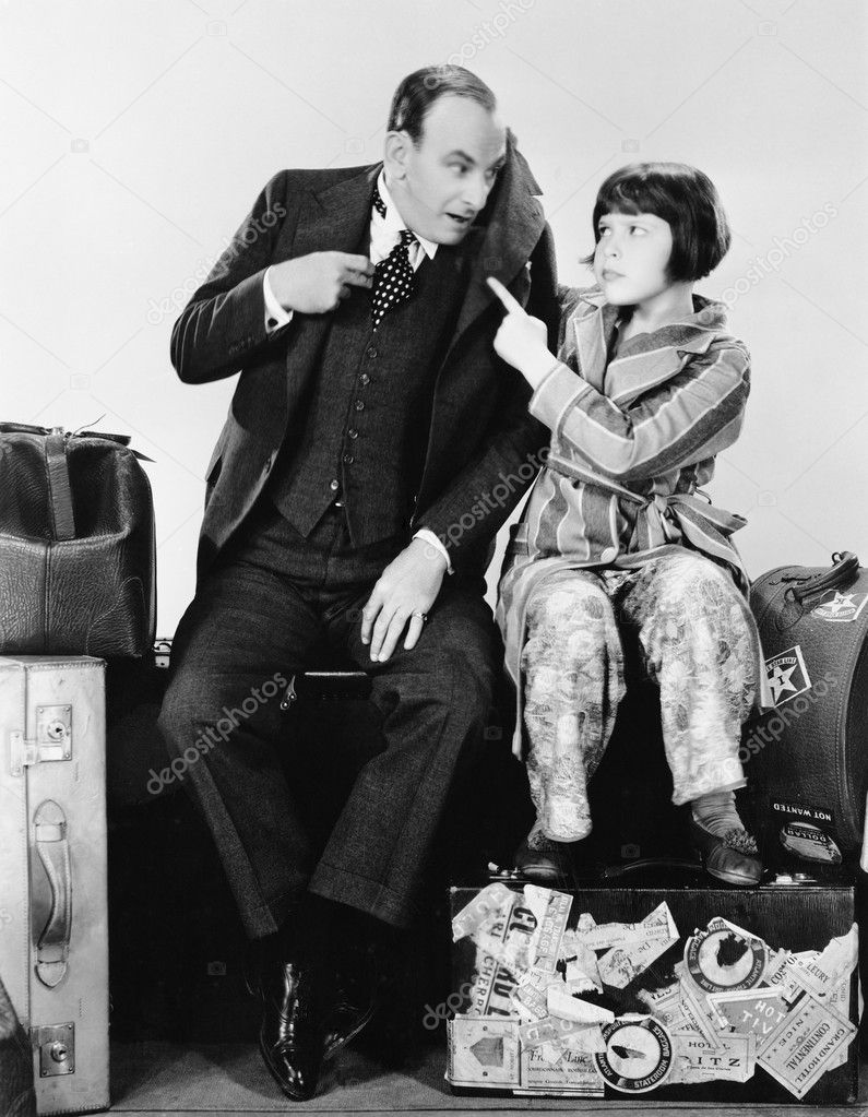 Father and daughter sitting together on luggage