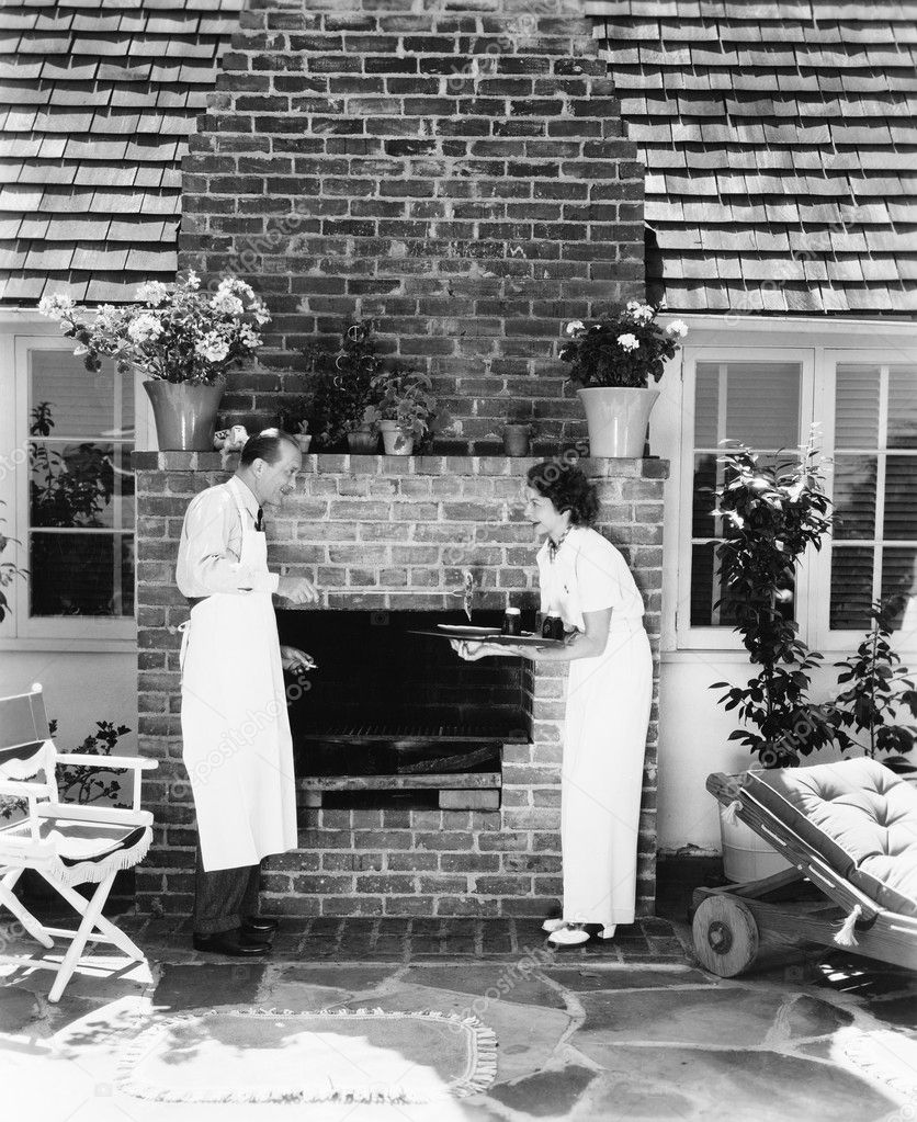 Man and woman at their barbecue in the back yard