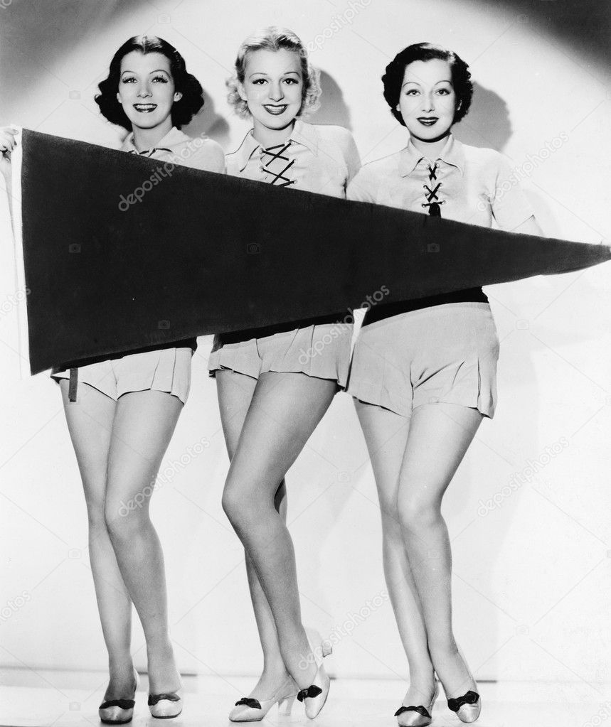 Portrait of three young women holding a banner and smiling