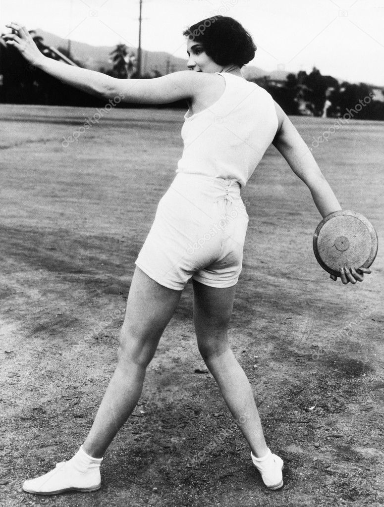 Rear view of a young woman throwing a discus