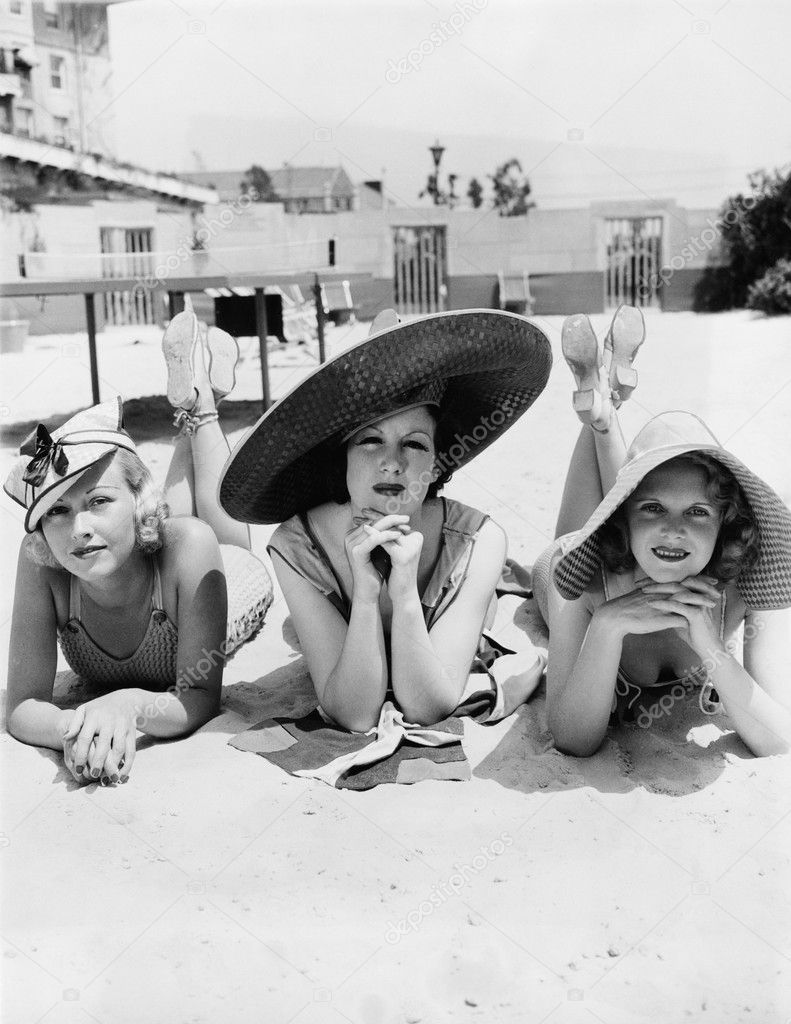Portrait of three young women lying on the beach