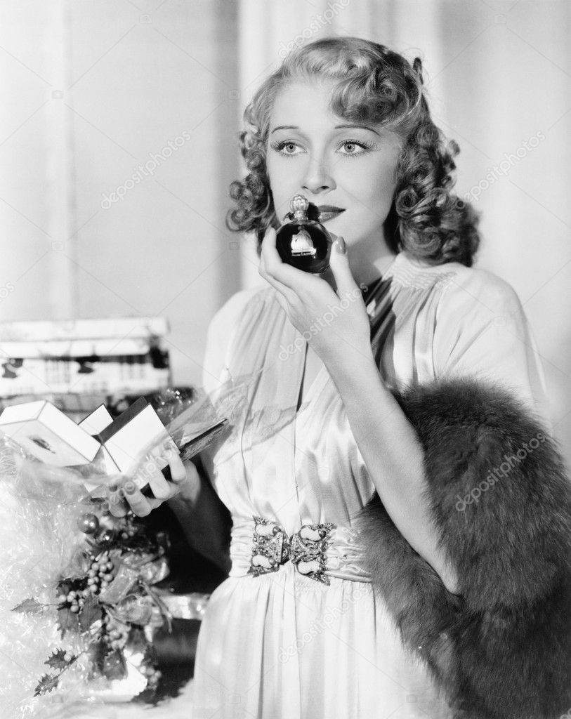 Young woman smelling perfume