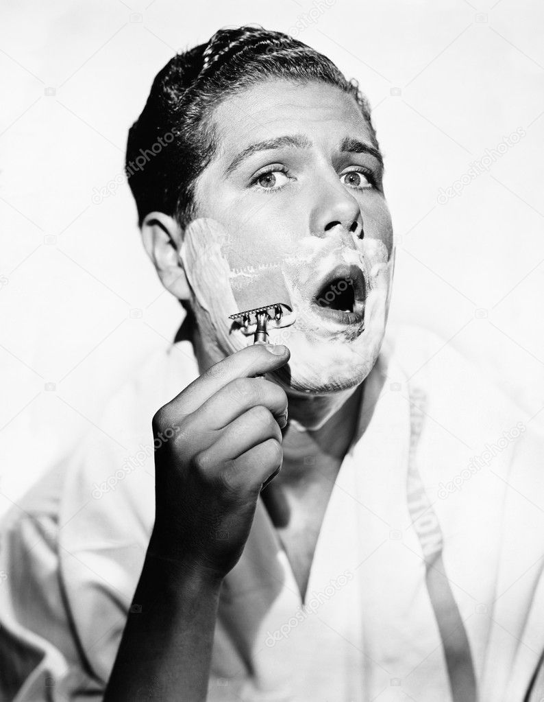 Portrait of a young man shaving