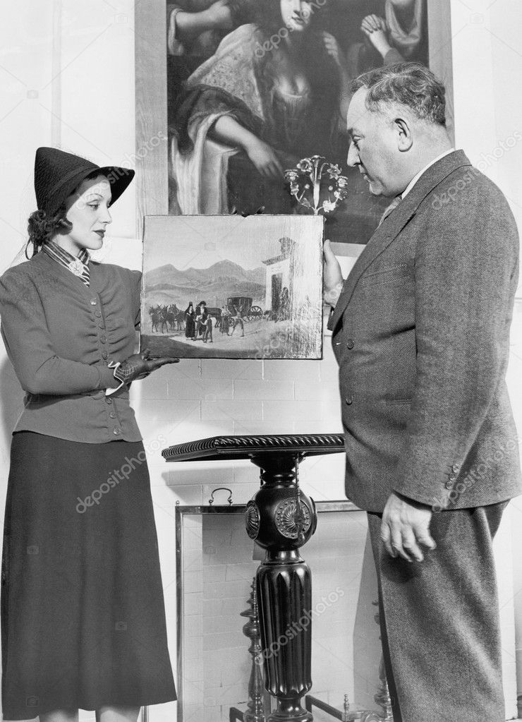 Woman showing an older man a piece of art