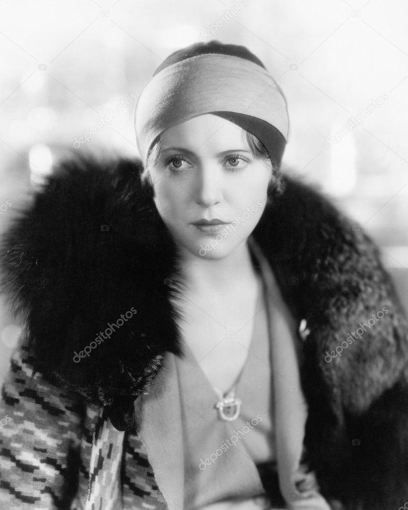 Woman in a fur collar looking sad into the distance