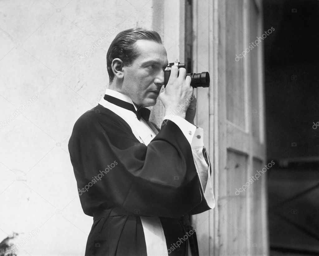 Man holding and looking through a camera