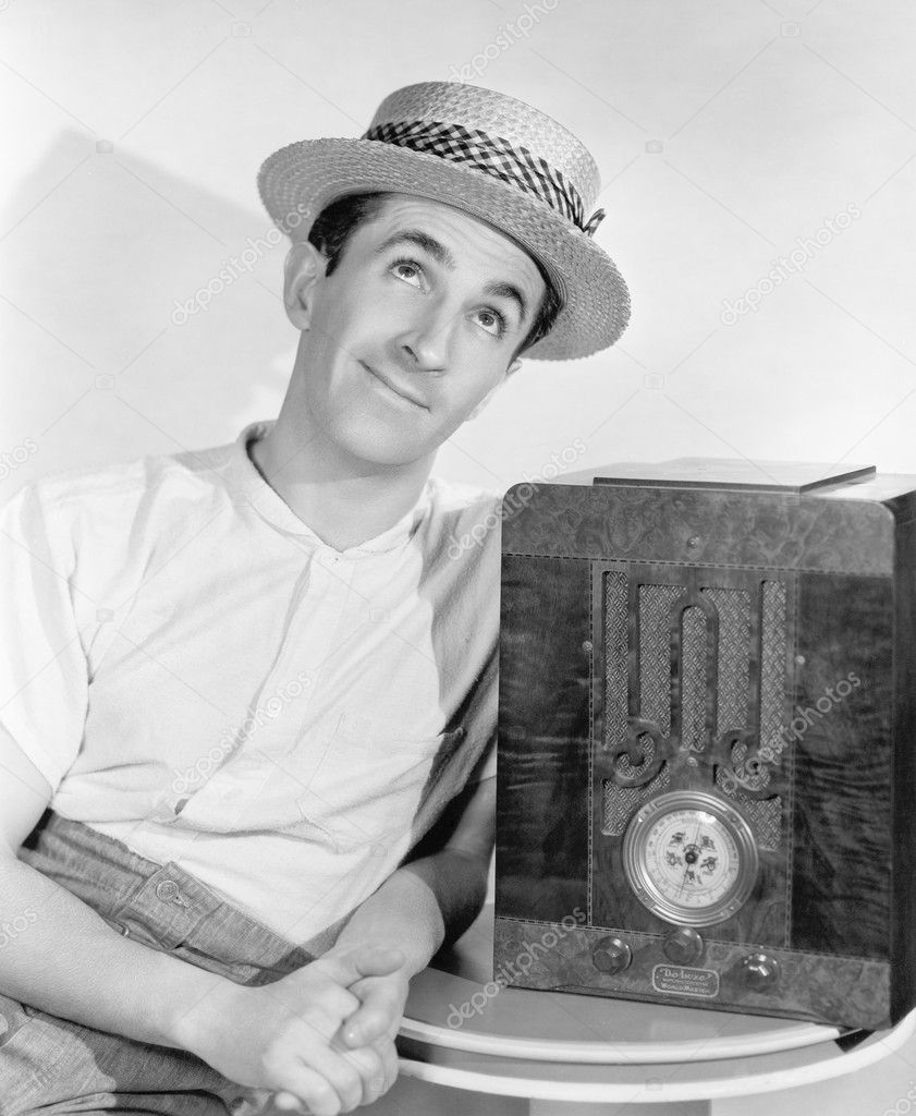 Man in straw hat listening to the radio