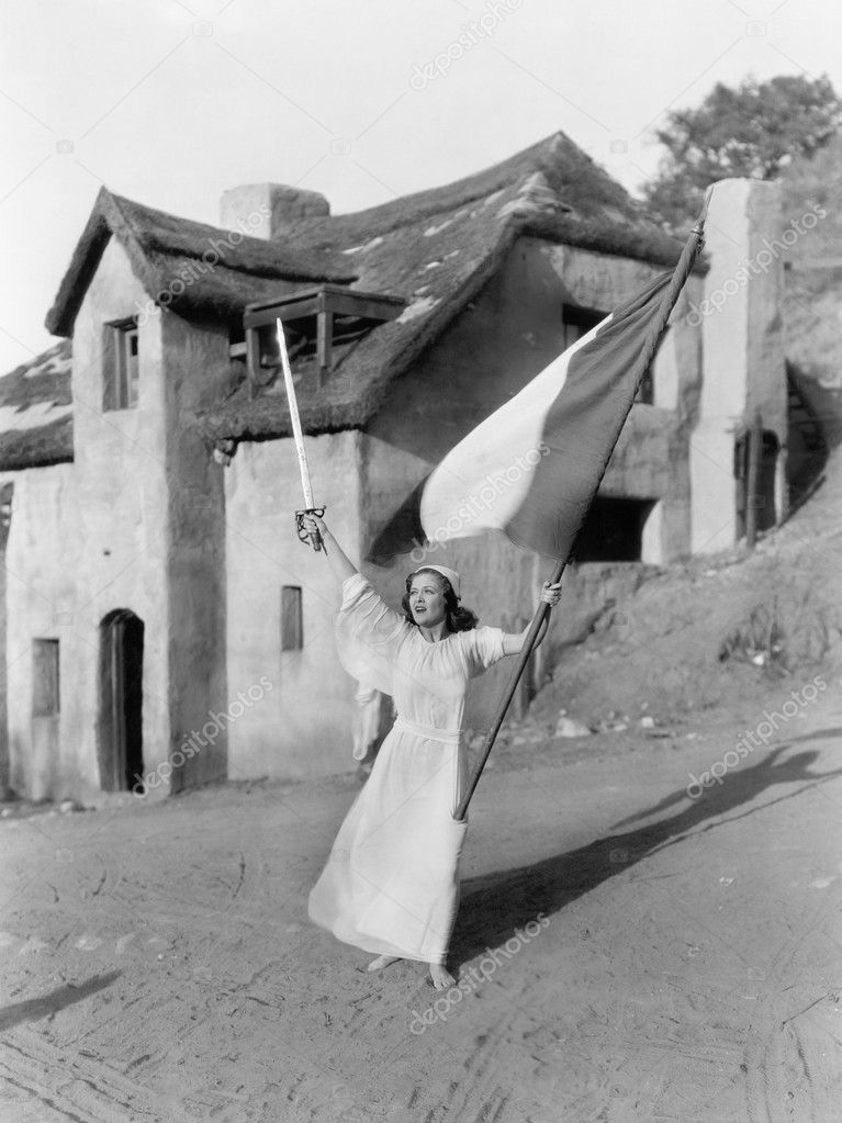 Young woman walking with a flag and a sword