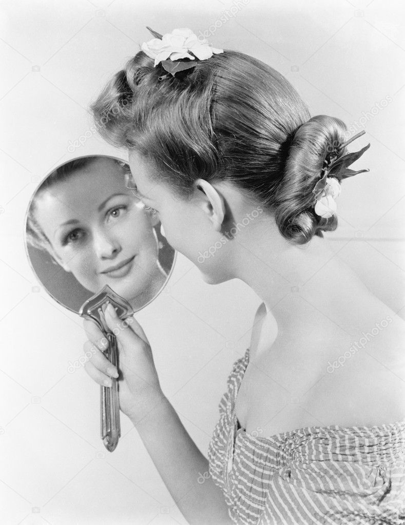 Reflection of a young woman, looking in a mirror