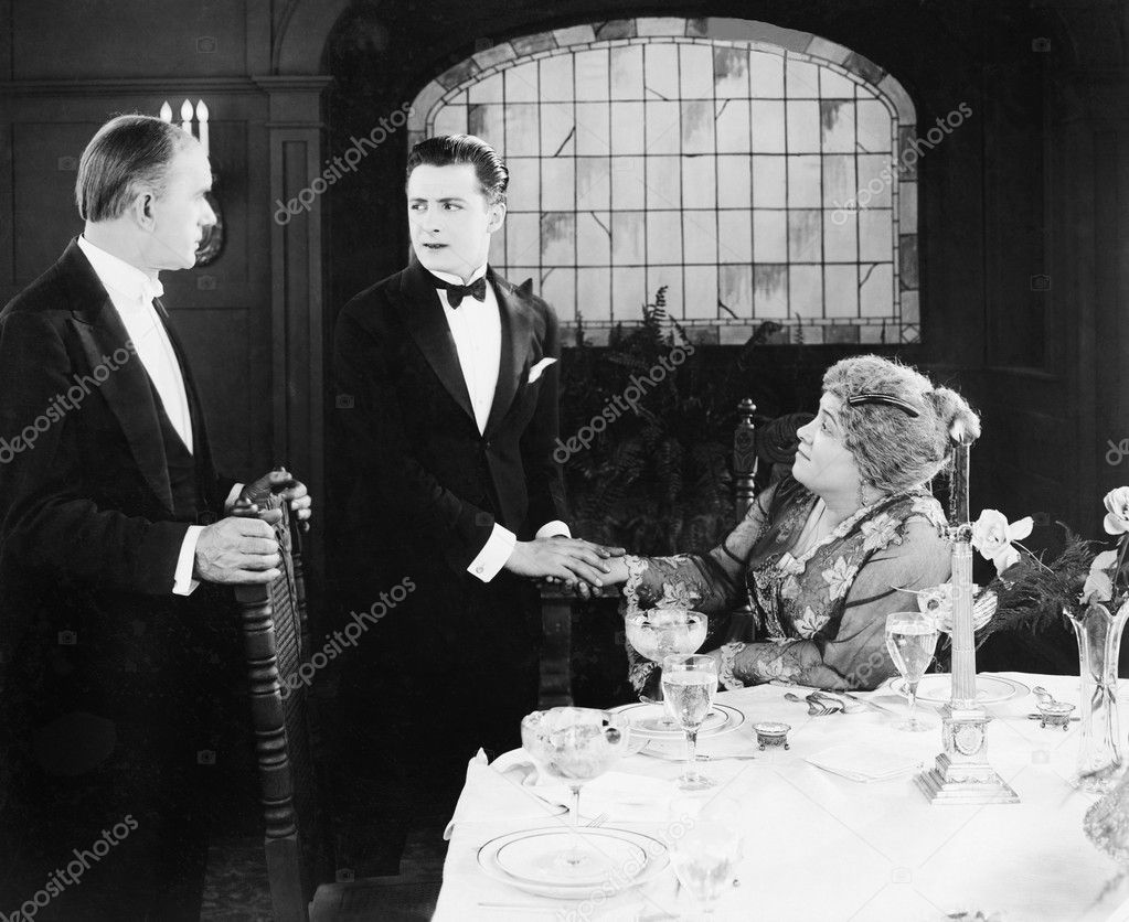 Young man greeting a couple at the dinner table
