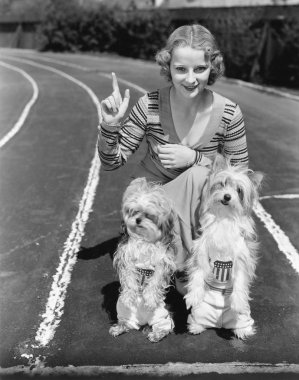 Woman with her two dogs on a race track clipart