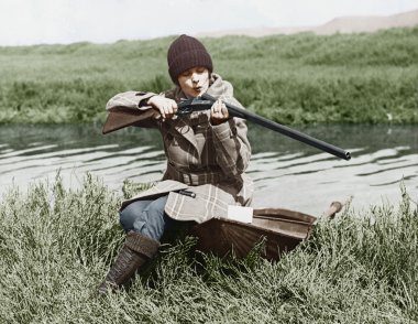 Female hunter with gun near river clipart