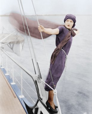 Woman leaning off boat into the wind clipart