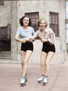 Portrait of two young women with roller blades clipart