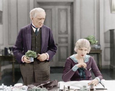 Older man standing next to a woman at her desk clipart