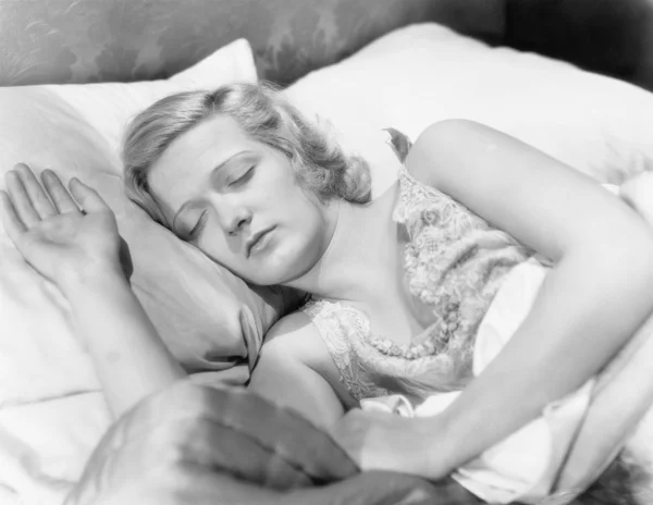 Young woman lying in her bed sleeping — Stock Photo, Image