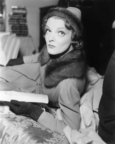 Žena v kabátě a klobouku číst časopis — Stock fotografie