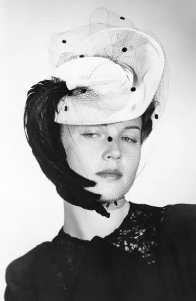 Mujer elegante con un sombrero interesante con un velo — Foto de Stock