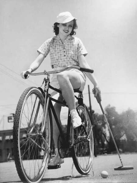 Mulher em uma bicicleta jogando pólo — Fotografia de Stock